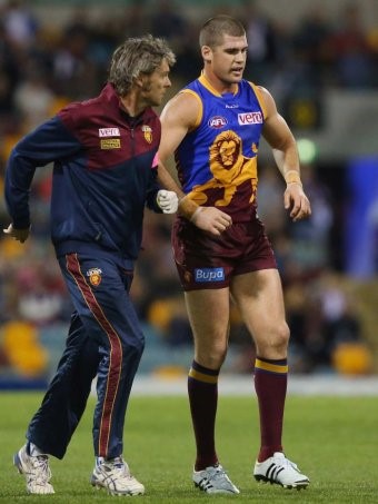 Jonathan Brown limps off Gabba pitch